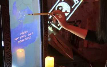 A player drawing a talisman at the physical station