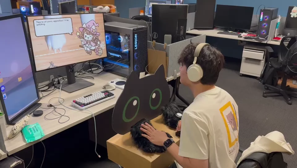 Player holding the two furry paw controls on the physical cat-shaped controller.