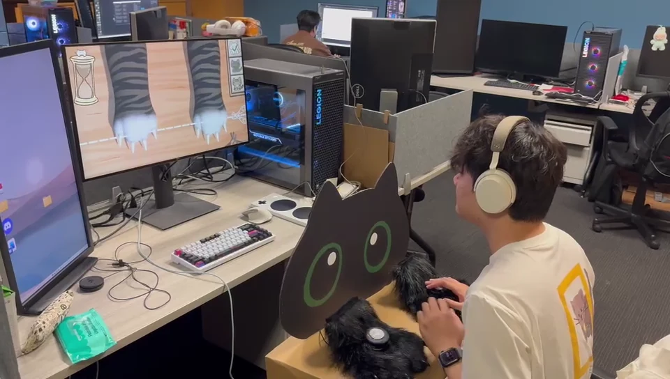 Player operating the paw controller while the monitor shows cat paws, claws, and the scissors timing line.